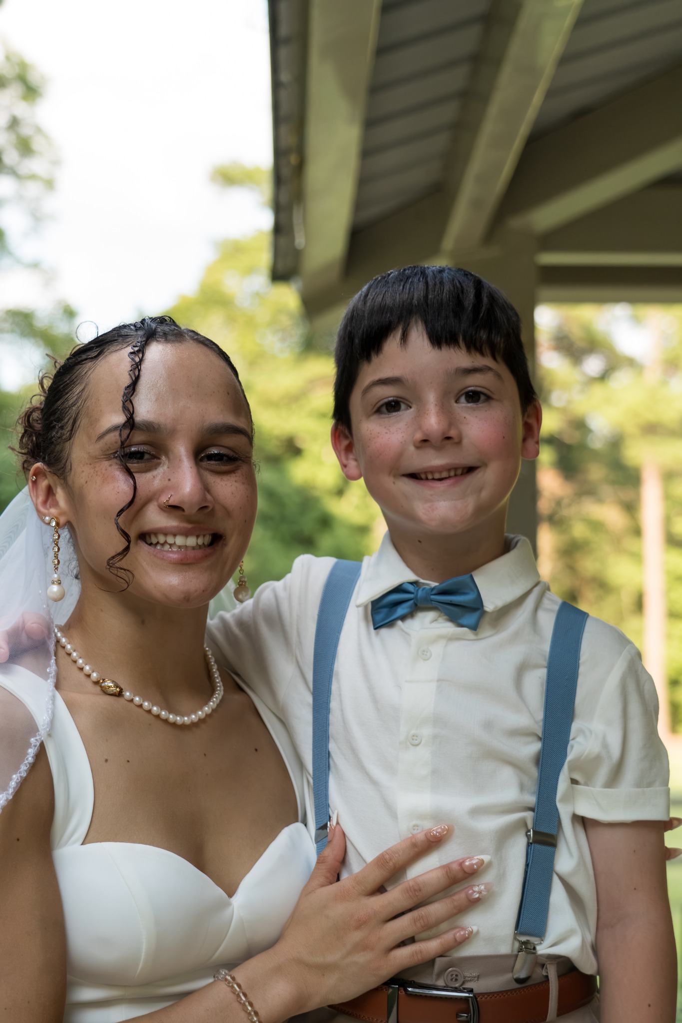 Bride and a young wedding guest wearing a blue bow tie
