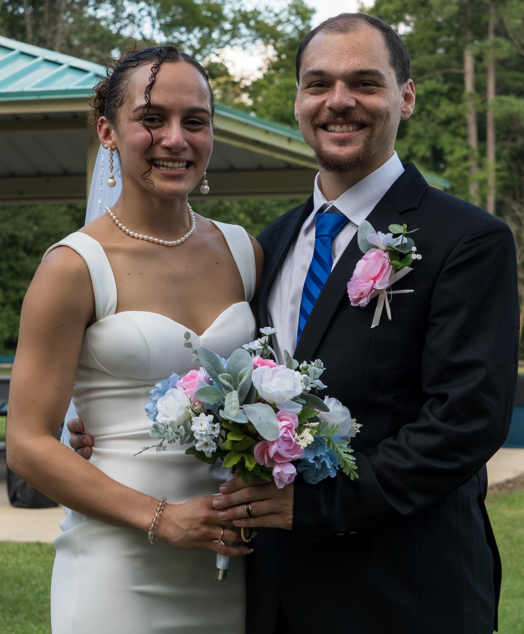 Bride and groom smiling together with a bouquet