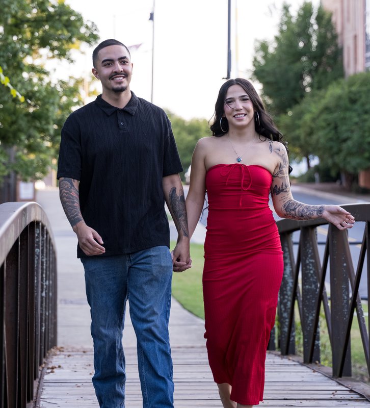 Couple smiling as they walk across a bridge
