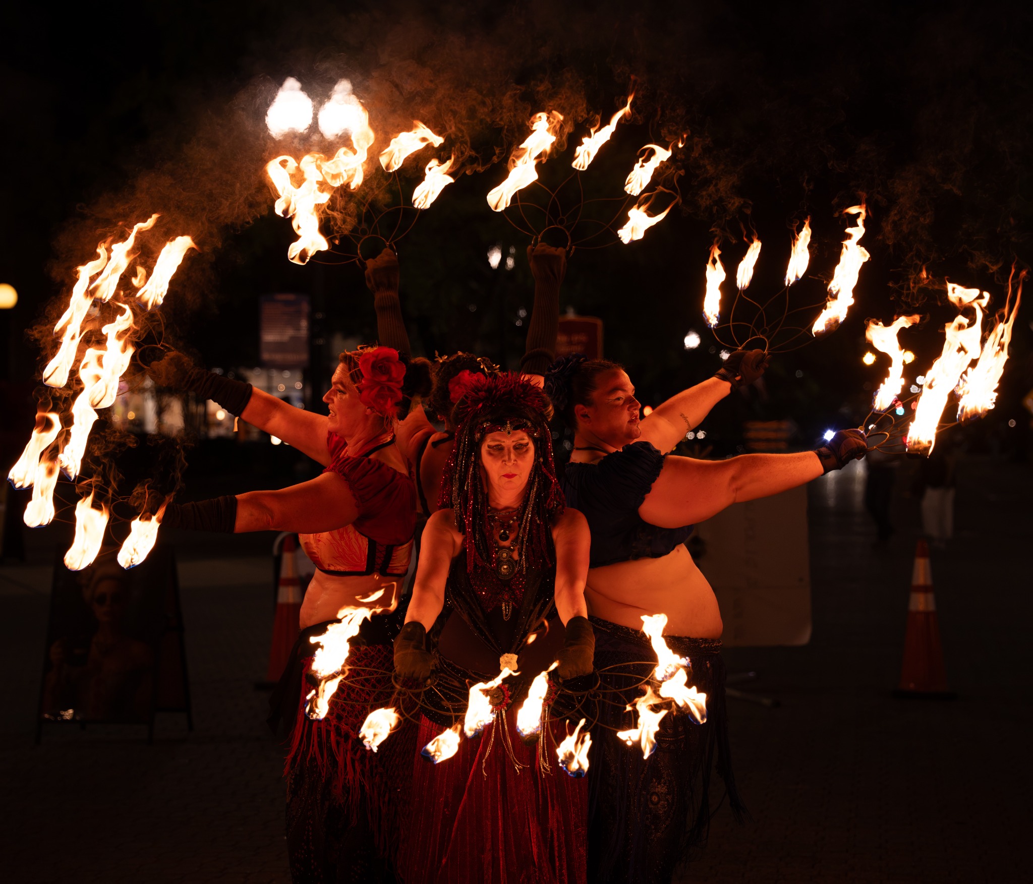 Fire performers arranged together with flaming fans raised around them at Dogwood Nights