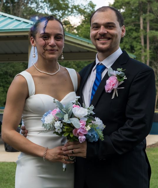 Newlyweds posing with a bouquet