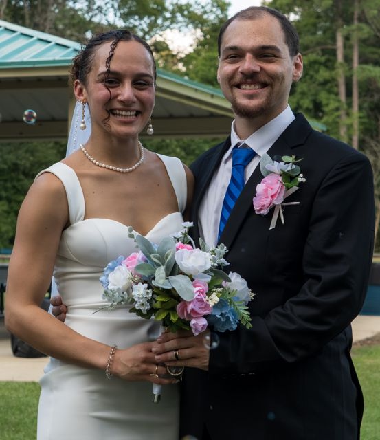 Newlyweds posing with a bouquet
