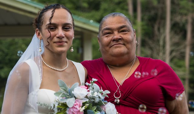 Newlyweds and guests posing together outdoors