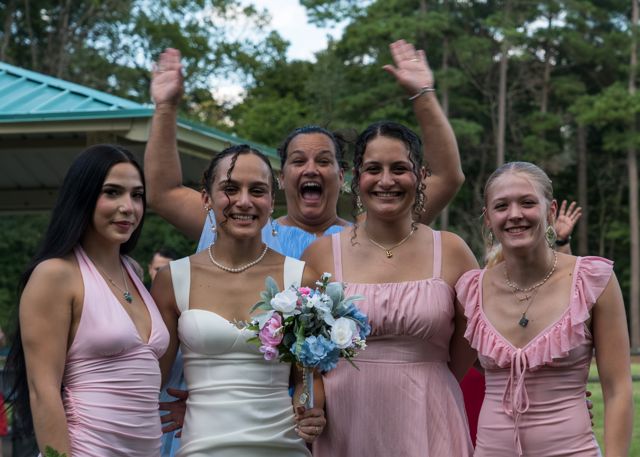 Newlyweds and guests posing together outdoors