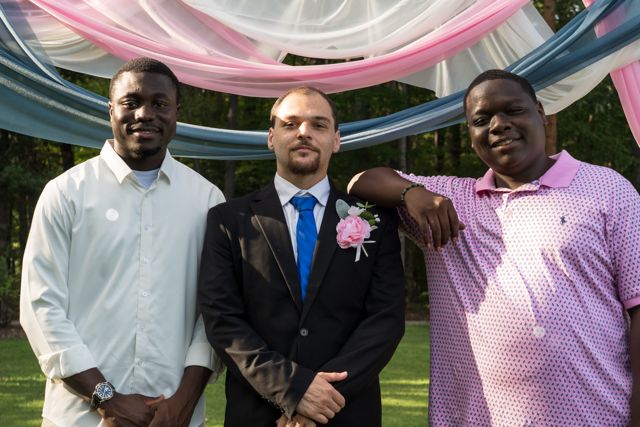 Newlyweds and guests posing together outdoors