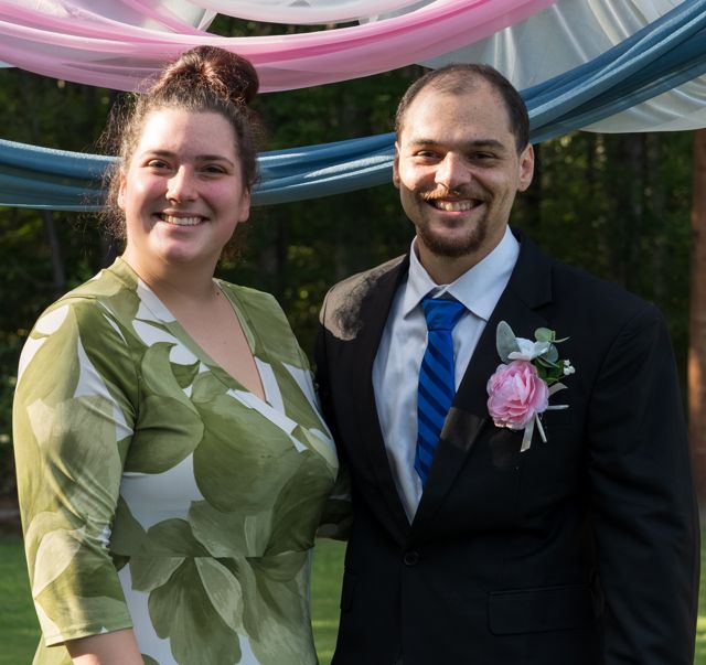 Newlyweds and guests posing together outdoors