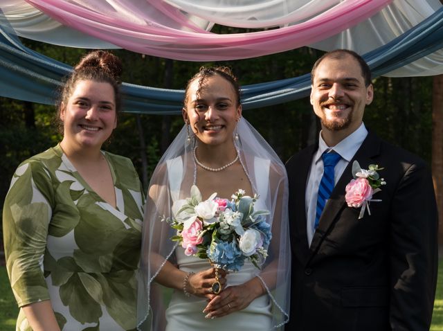 Newlyweds and guests posing together outdoors