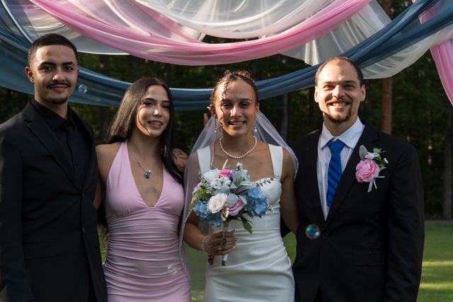 Newlyweds and guests posing together outdoors