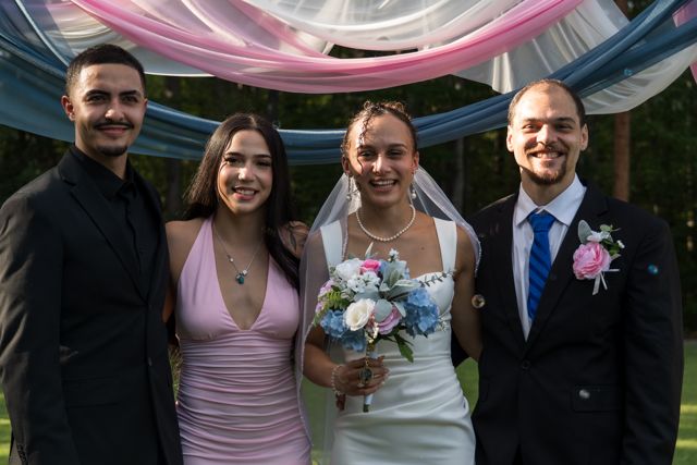 Newlyweds and guests posing together outdoors