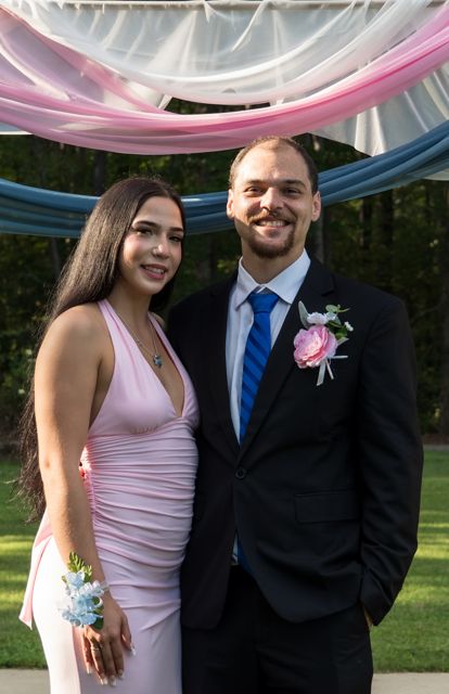 Newlyweds and guests posing together outdoors
