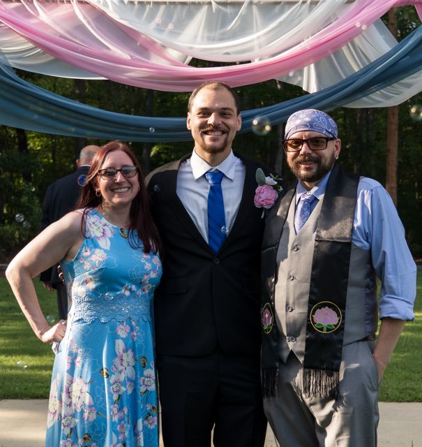 Newlyweds and guests posing together outdoors