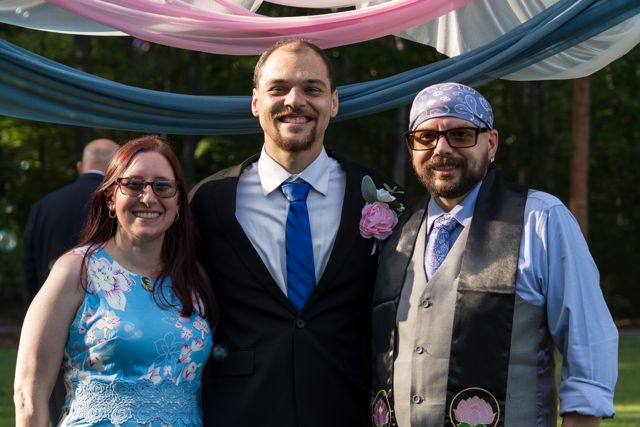 Newlyweds and guests posing together outdoors