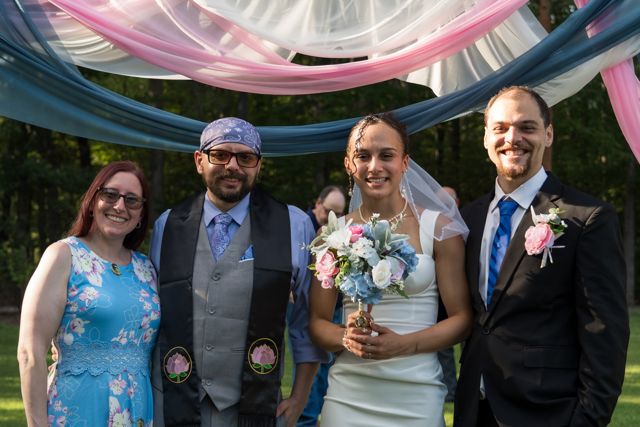 Newlyweds and guests posing together outdoors