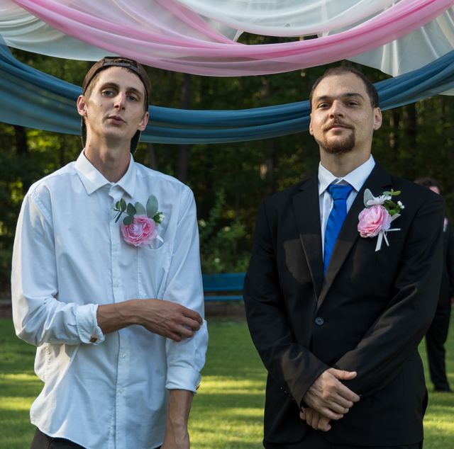 Newlyweds and guests posing together outdoors